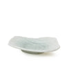A small, shallow, organic shaped ceramic dish with a textured surface and a light gray base, shown on a plain white background.