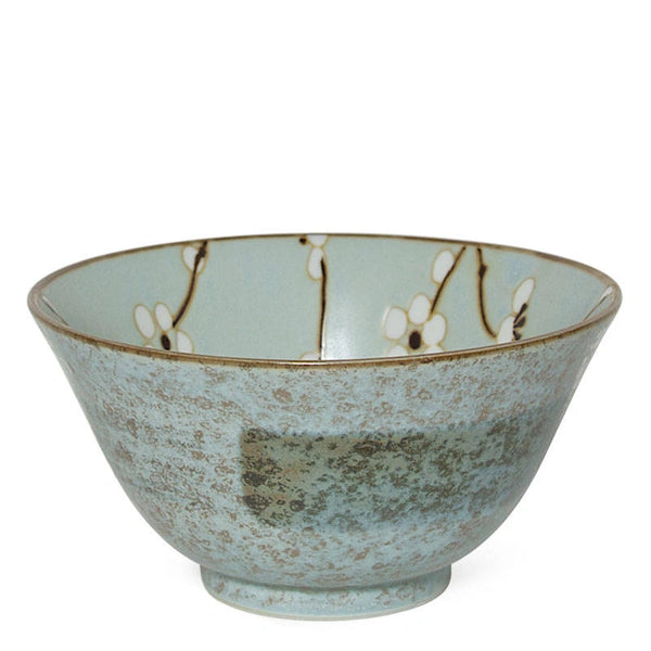 A ceramic bowl with a textured, speckled light blue-green glaze, decorated with delicate white cherry blossoms on a branch pattern inside the rim, set against a plain white background.