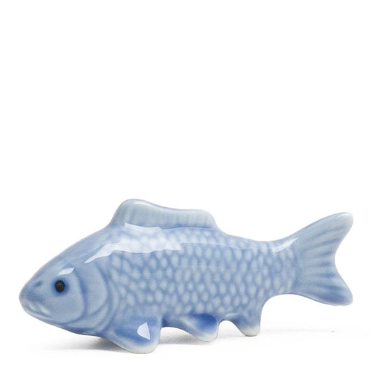 A glossy ceramic fish figurine in light blue with darker blue shading, shown against a plain white background.