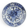 A round ceramic plate with a blue and white hand-painted floral design, photographed from directly above on a white background.