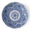 A round ceramic plate with a blue and white floral pattern, featuring a central floral medallion and detailed botanical designs around the rim.