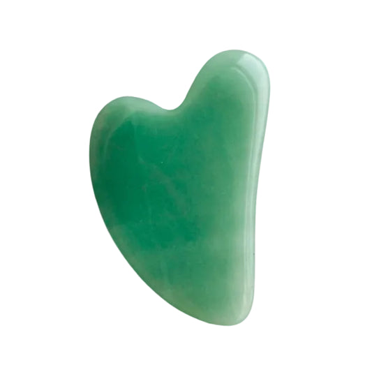 Green gua sha tool on a white background