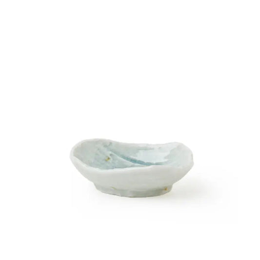A small handmade ceramic dish with a light blue and white glaze, photographed on a seamless white background.