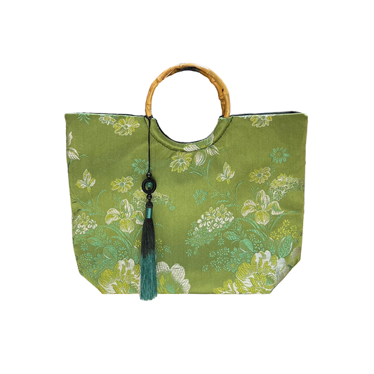 Green floral-patterned tote bag with a bamboo handle on a white background