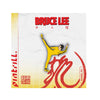 Bruce Lee enamel pin packaging with yellow figure and red text on a white background