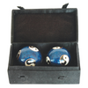 Two blue decorative balls with white patterns in a black box