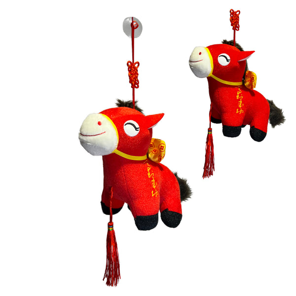 Two red plush horses with tassels on a white background