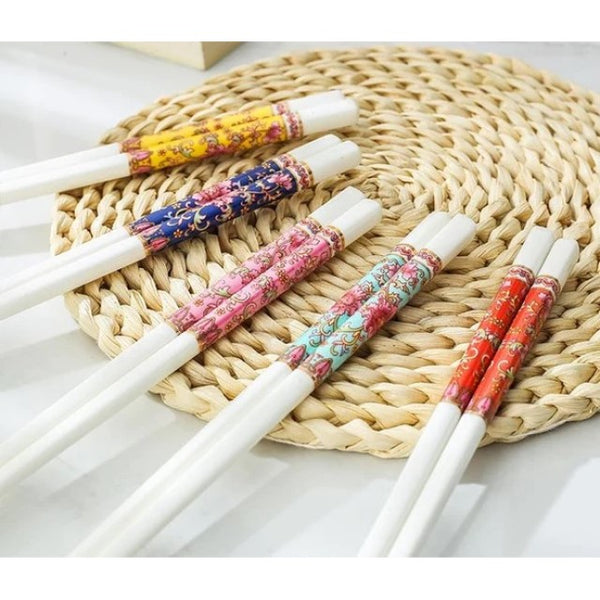 Floral Bone China Chopstick Set. Chopsticks are on a woven mat and comes in 5 accented colors on white: yellow, blue, pink, green, and red.