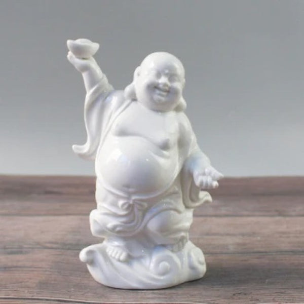 6"H White ceramic smiling buddha with right hand raised. Ingot is in the right hand,