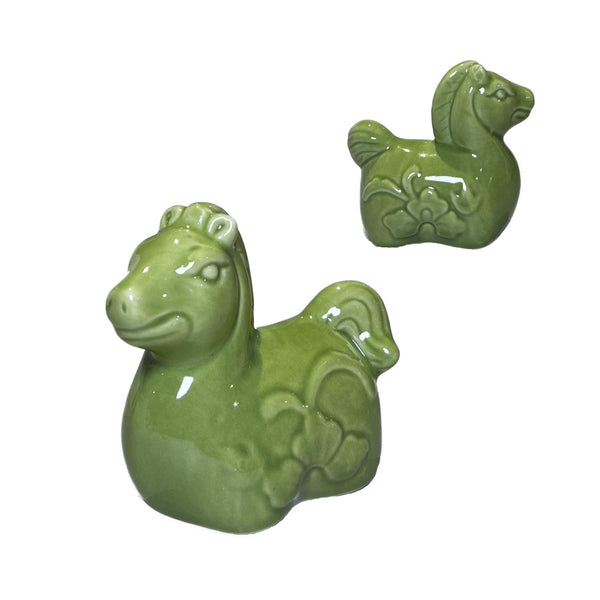 Two green ceramic horse figurines on a white background