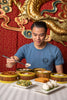 Man wearing the Jing Fong T-Shirt - Steel Blue while eating dim sum.