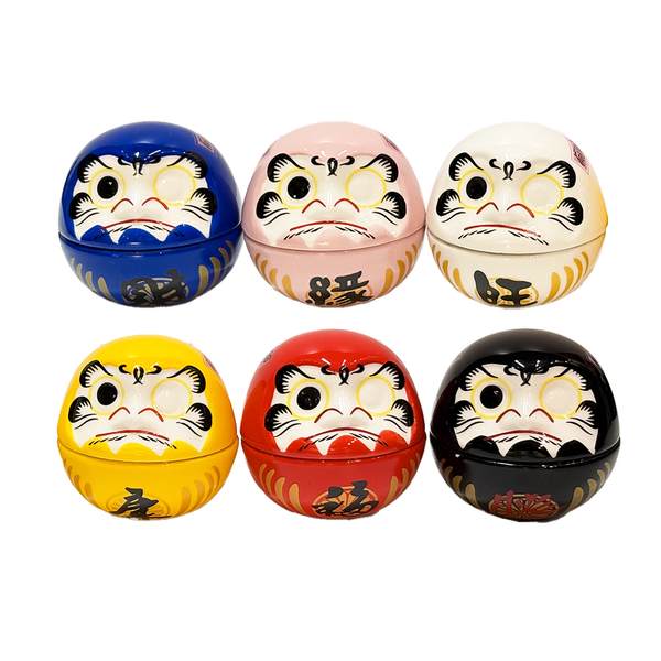 Ceramic daruma figurines in blue, pink, white, yellow, red, and black