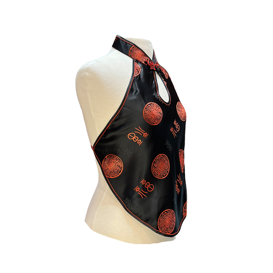 Black halter top with red patterns on a mannequin against a white background