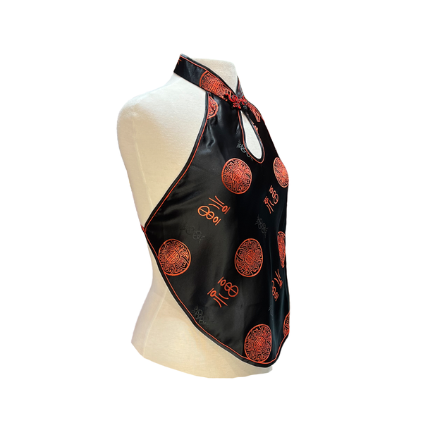 Black halter top with red patterns on a mannequin against a white background