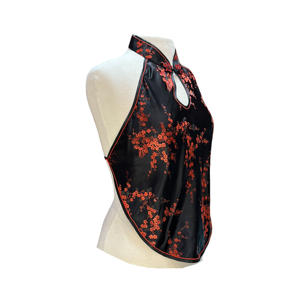 Black halter top with red floral pattern on a mannequin against a white background