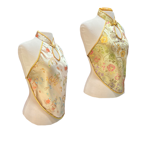 Two floral-patterned tops on mannequins with gold accents against a white background