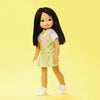 The Jilly Doll standing upright with a yellow background.