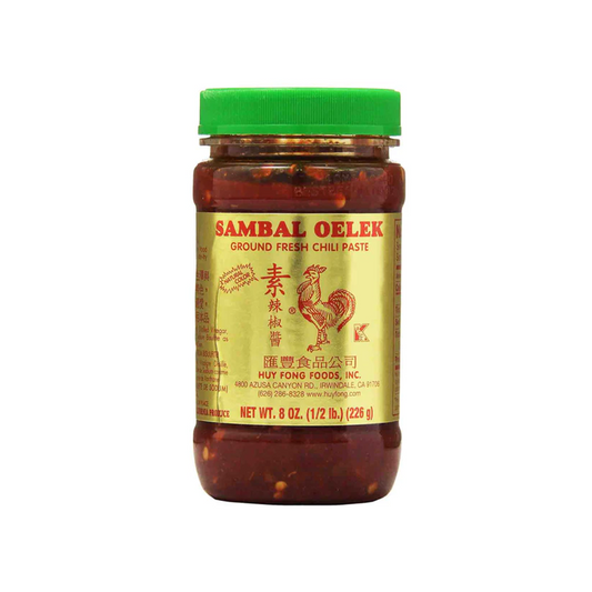 Jar of Sambal Oelek chili paste with a green lid on a white background