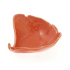 Coral-colored leaf-shaped dish on a white background