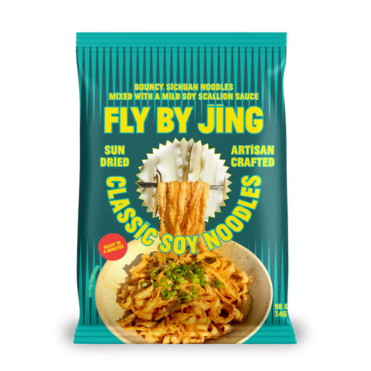 Packaging of Fly By Jing Classic Soy Noodles with teal background and noodle imagery.