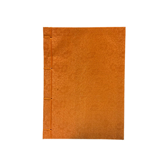 Orange notebook with a textured cover on a white background
