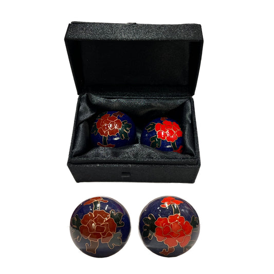 Pair of balls with floral design in a black box on a white background