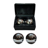 Silver spherical objects in an open black box on a white background