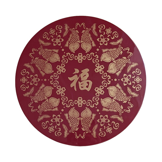 Decorative red circular item with gold fish and floral patterns on a white background