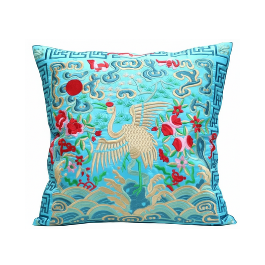 Decorative pillow with embroidered crane and floral patterns on a blue background