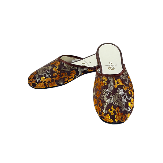 Pair of decorative slippers with intricate patterns on a white background