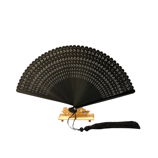 Black fan with lace design and tassel on wodden stand