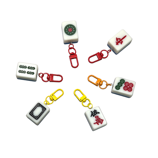 Mahjong tile keychains with colorful clips on a white background