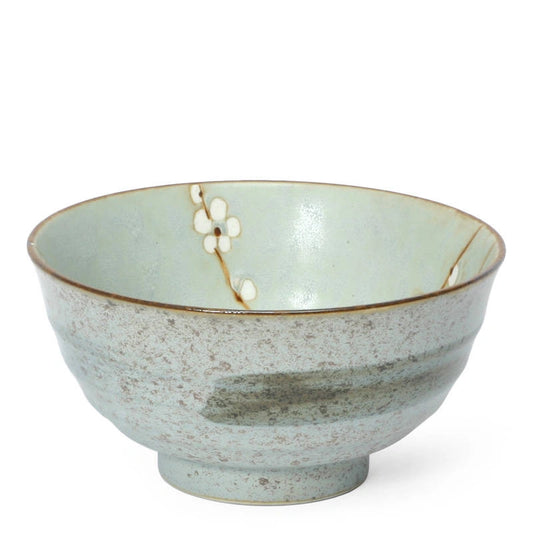 A ceramic bowl with a speckled light gray-green exterior and a glossy pale blue-green interior, decorated with a delicate white floral branch motif near the rim.