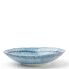 A shallow round ceramic plate with a flared rim, decorated with vertical blue stripes and a textured ribbed pattern, set against a plain white background.
