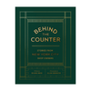 Book cover for 'Behind the Counter: Stories from New York City Shop Owners' with gold text and geometric border lines on a dark green background.