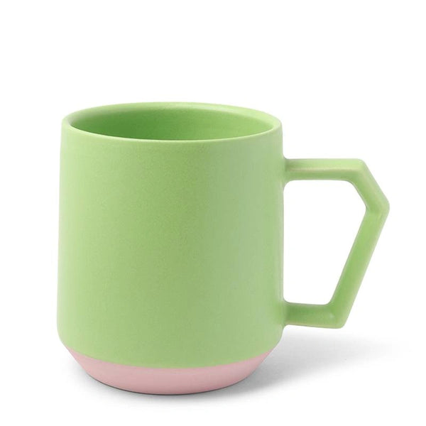 A modern, angular mug with a pastel green body and soft pink base. It features a geometric handle, conveying a fresh, minimalist design aesthetic.