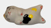 Ceramic cat-shaped object with yellow, white, and black colors on a white background.