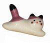 Ceramic cat-shaped object with white, purple, and black colors on a white background.