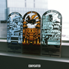 Three decorative metal bookmarks of New York City Chinatown scenes with illuminated center, on a reflective surface.