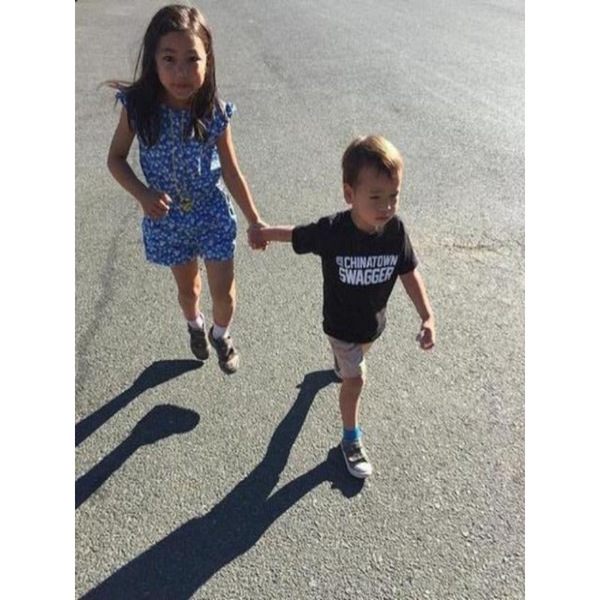 Little girl in a dress with a little boy wearing a cool black Chinatown Swagger T-shirt