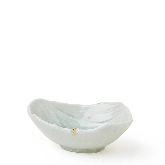 A small, organic-shaped ceramic bowl with a light blue-green glaze and a rough, hand-painted texture, set against a plain white background.