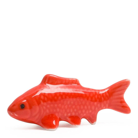 A glossy red ceramic fish-shaped dish or figurine with a textured scale pattern, shown against a plain white background.