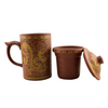 Reddish mug with dragon design, infuser, and matching cup with lid on a white background