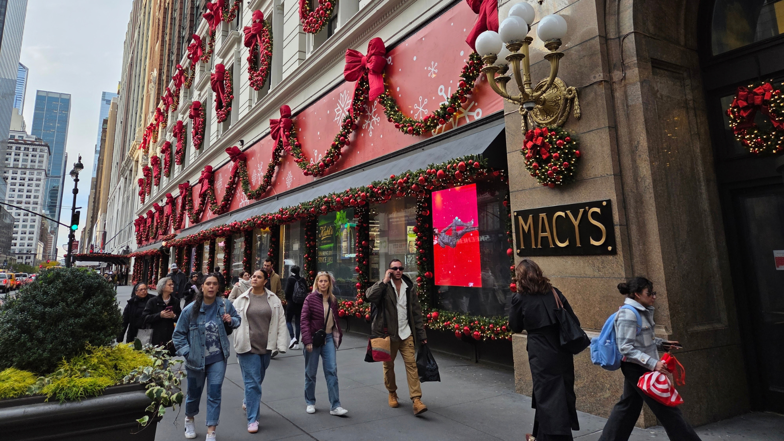 Exterior of Macy's Herald Square with winter holiday decor and people walking in front