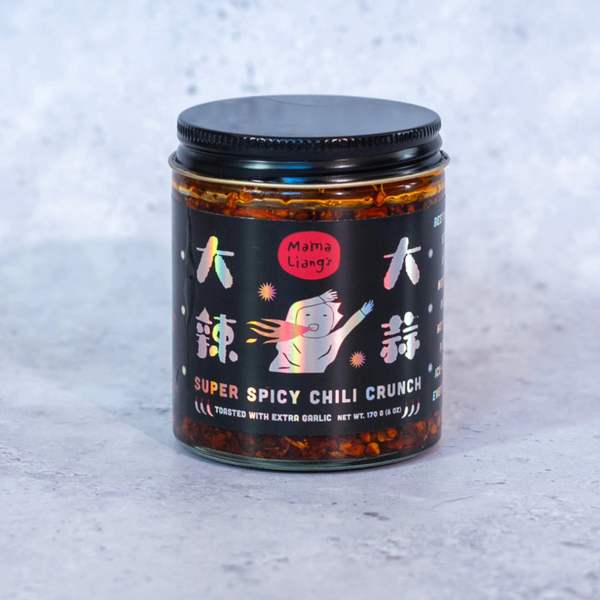 A glass jar of Mama Liang Super Spicy Chili Crunch with a black lid and black label, set against a light gray textured background.