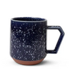 Navy blue speckled mug with a terracotta base on a white background
