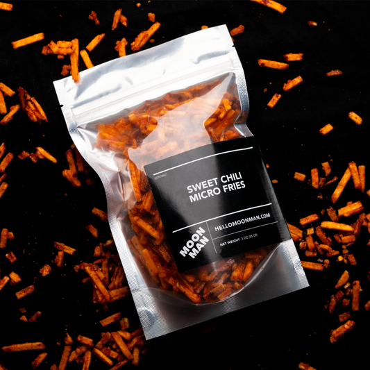 Package of Sweet Chili Micro Fries with scattered fries on a black background