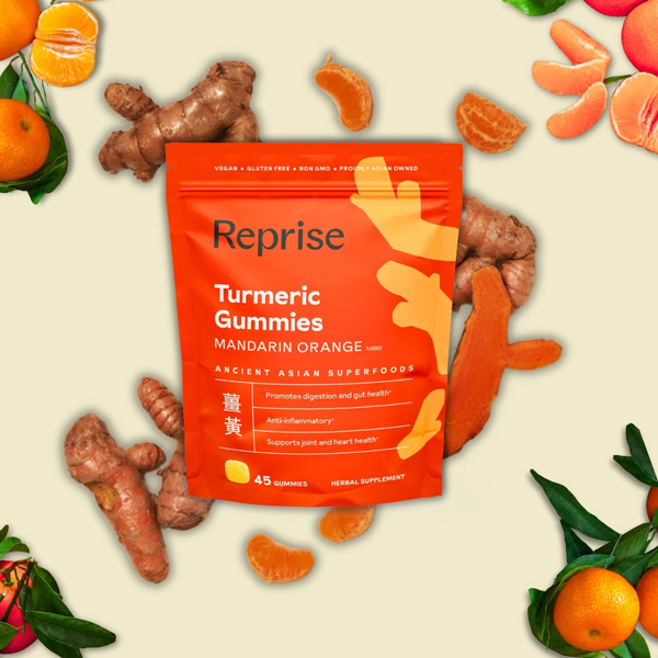 Bag of Reprise Turmeric Gummies surrounded by ginseng and orange slices