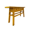 Yellow wooden table with three drawers on a white background