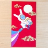 Red envelope with cartoon character on a wooden surface